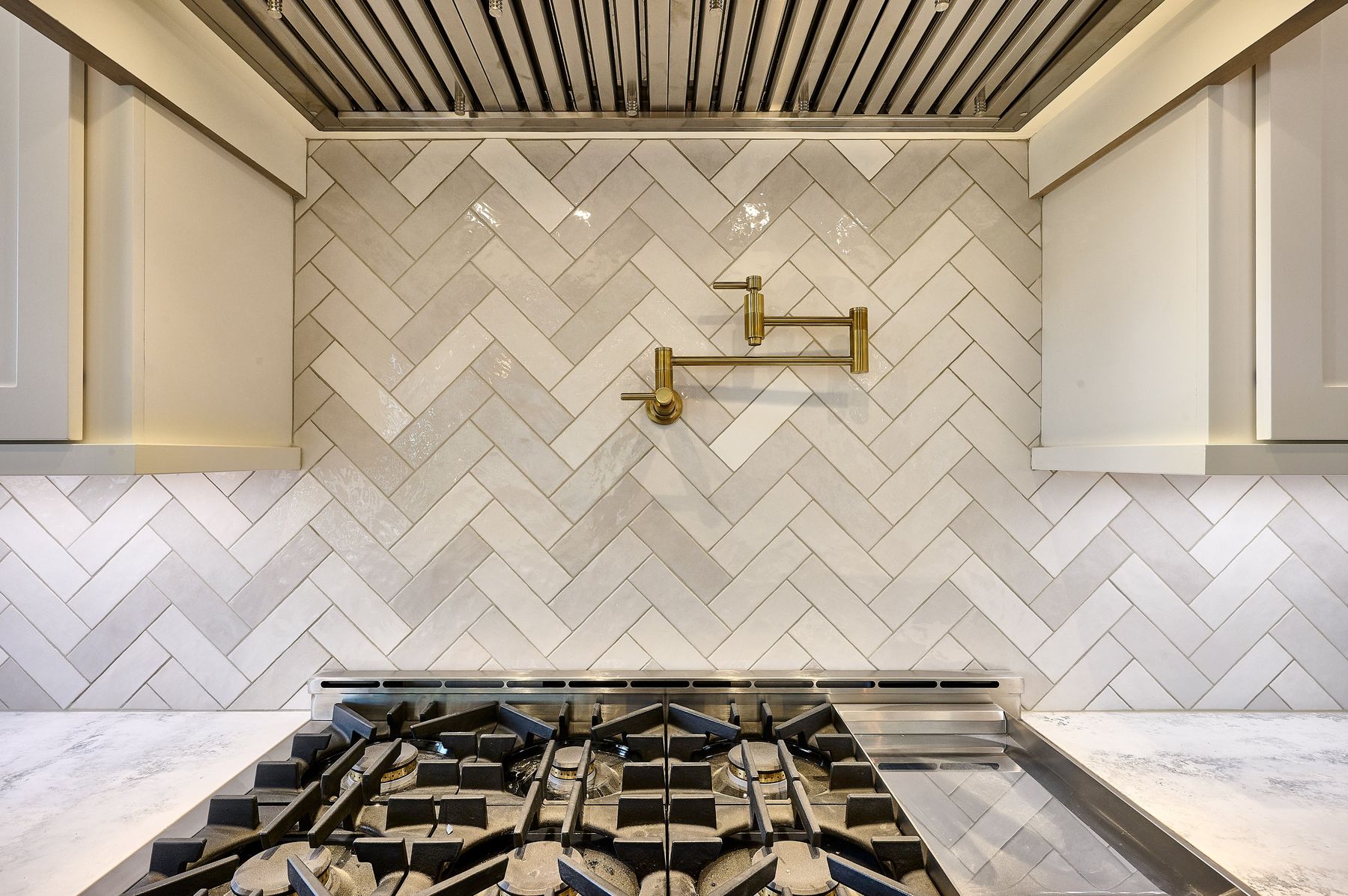 Cream herringbone tile backsplash