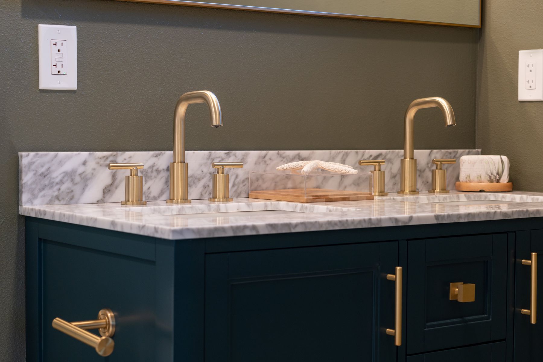 Navy vanity cabinetry with marble top and brass hardware