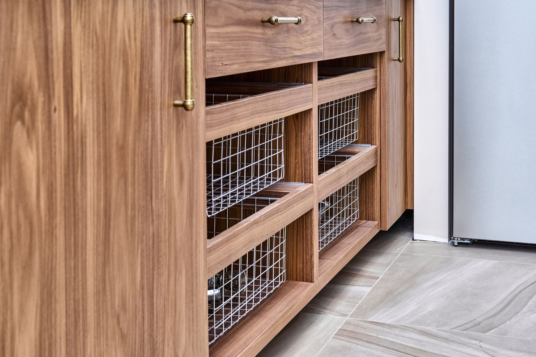 Walnut pantry cabinets with pull-out wire baskets