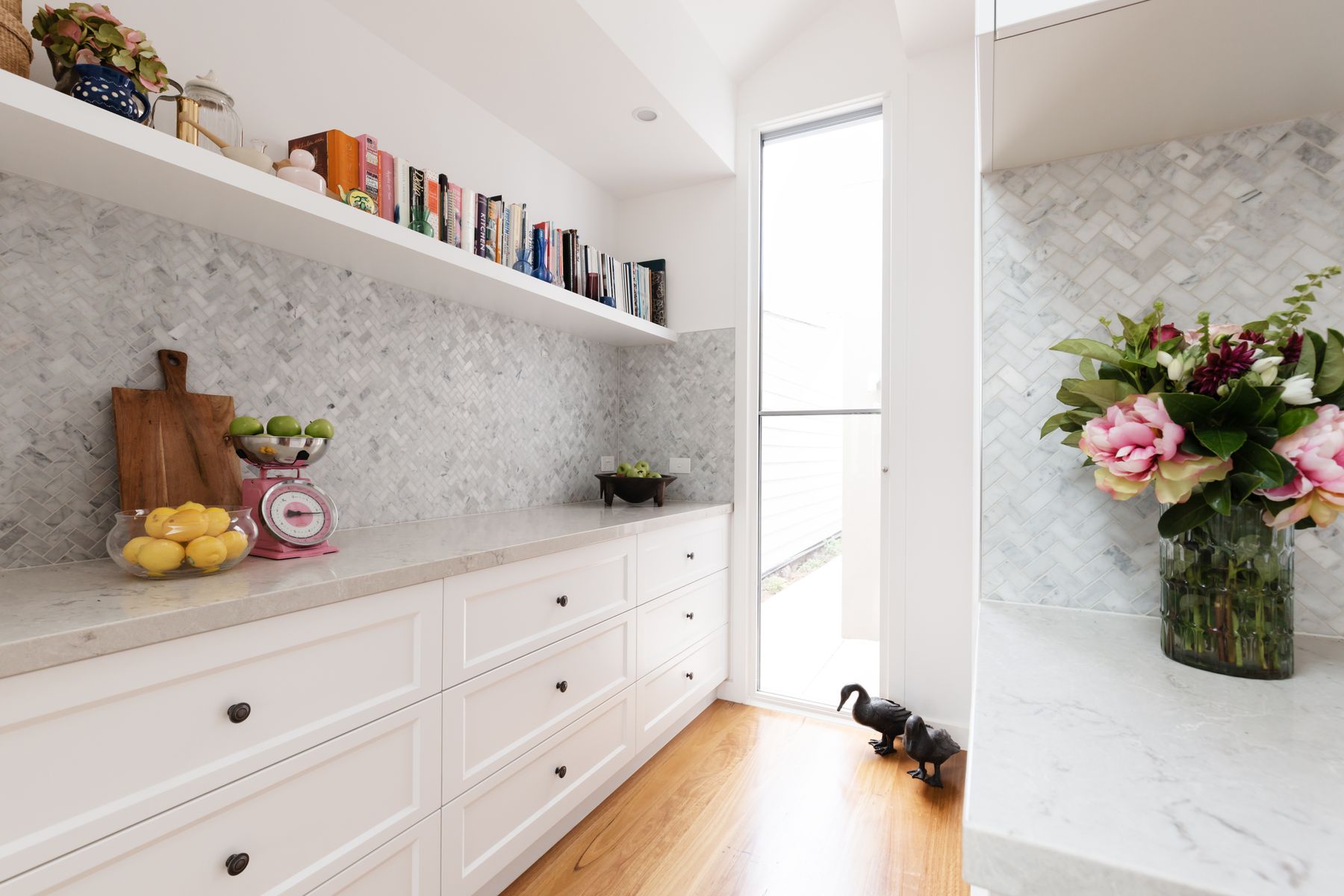 Marble herringbone butler's pantry with white drawers