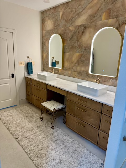 Double vanity with arched mirrors and accent tile wall in Niceville