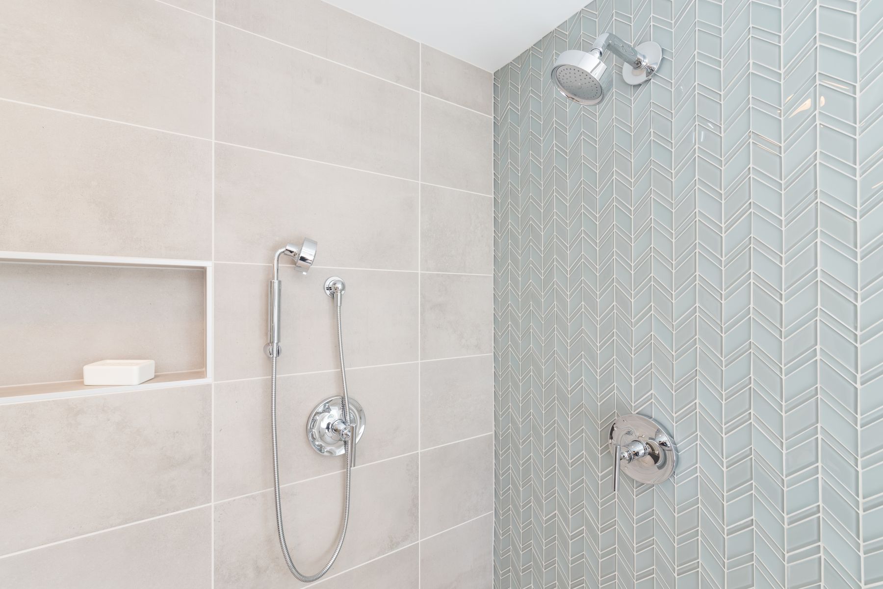 Aqua herringbone and large-format tile shower
