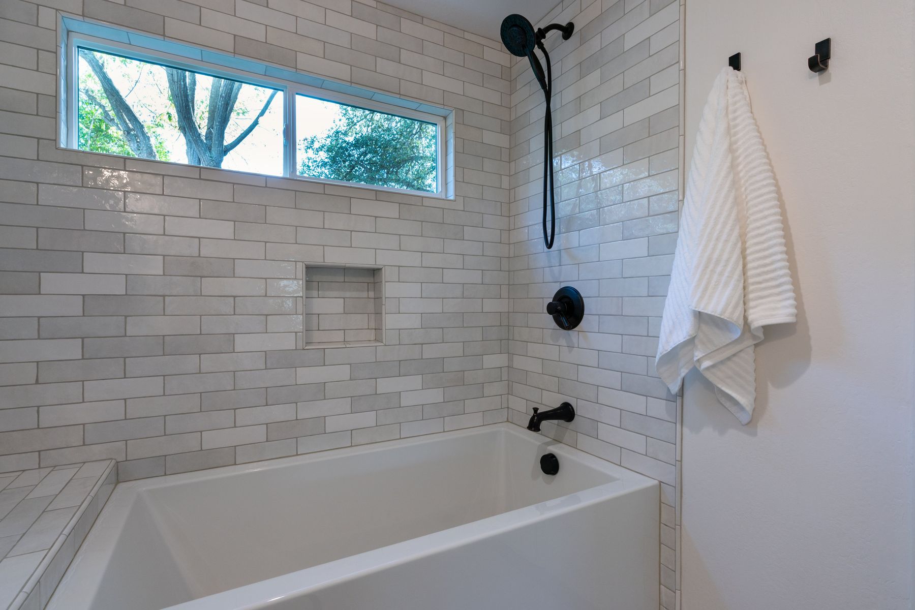 White subway tile tub surround with niche
